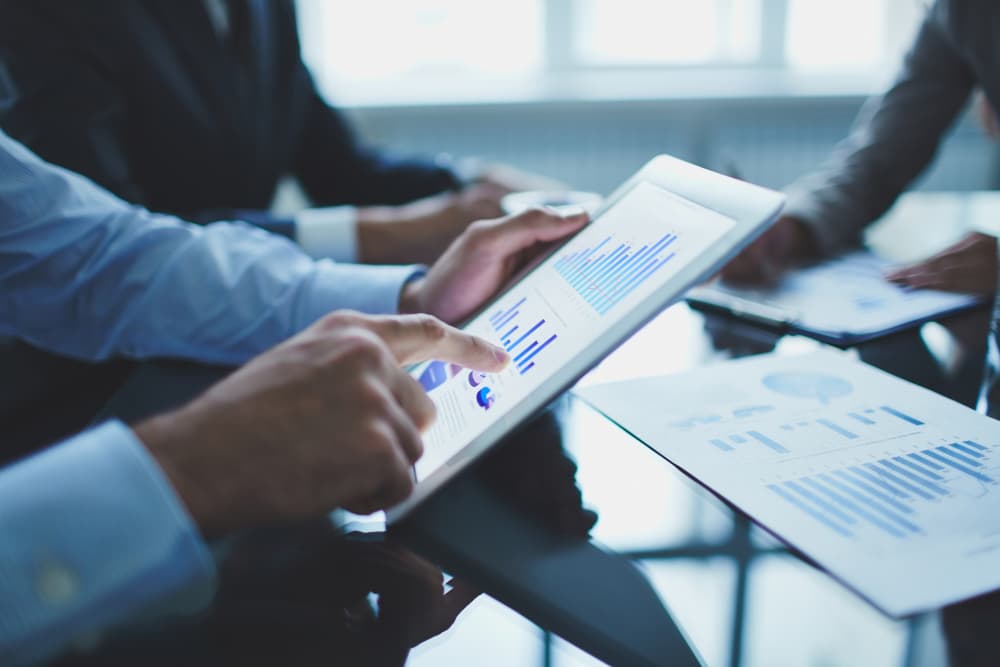 Man using an iPad to calculate ROI provided by managed IT services. 